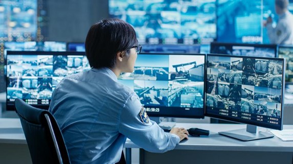 A person sitting at a desk with multiple monitors

Description automatically generated