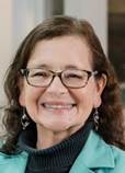 A person wearing glasses and a turquoise jacket

Description automatically generated